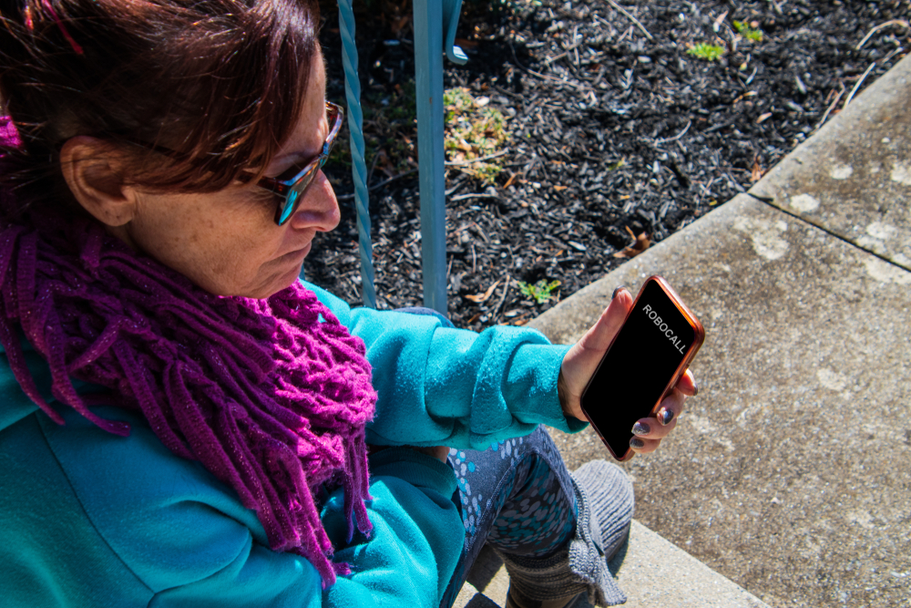 Middle aged baby boomer caucasian woman looking at her phone with anger